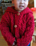 Malabrigo Worsted Merino Yarn, color ravelry red #611, baby cable sweater